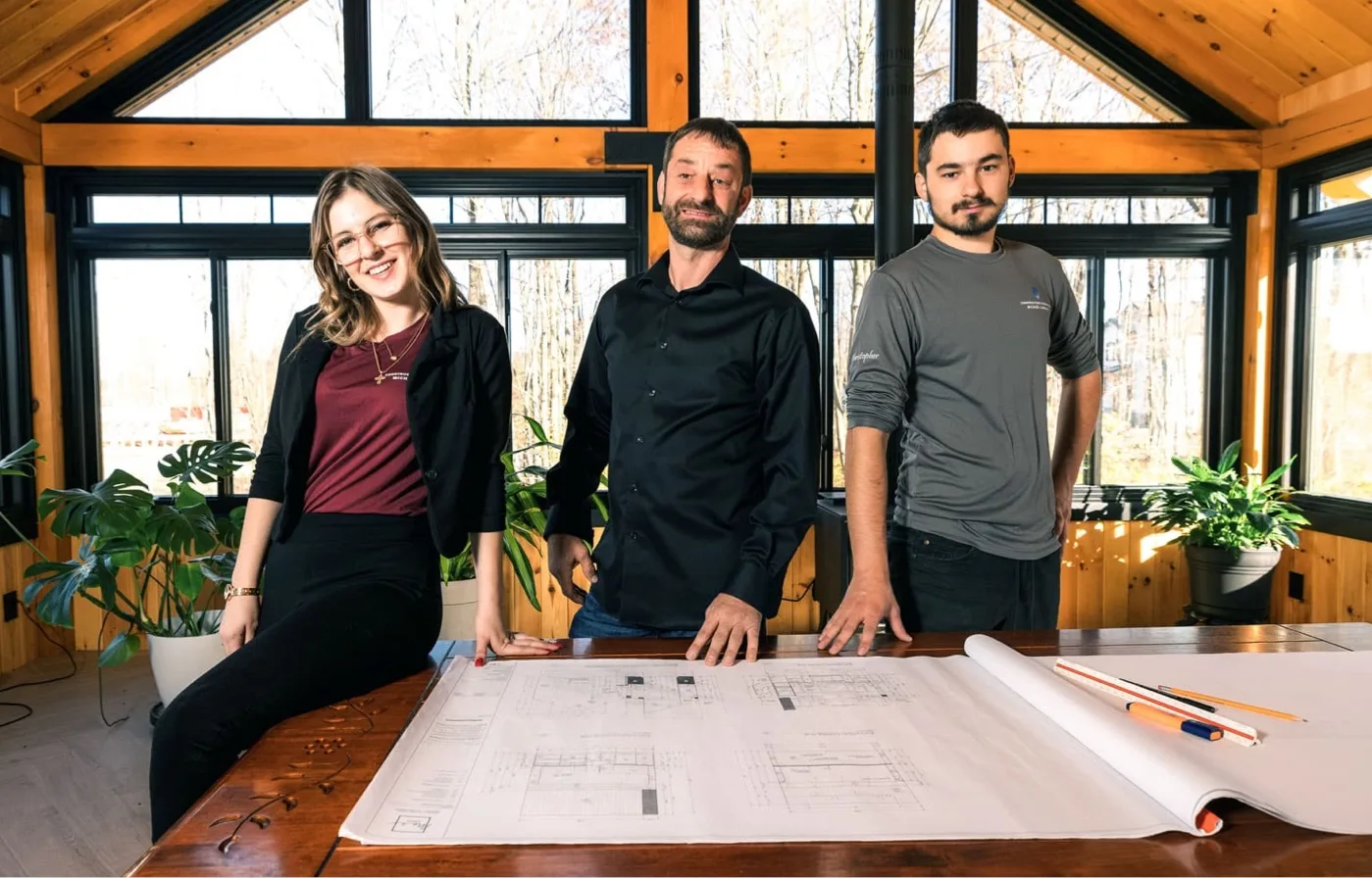 equipe Équipe professionnelle d’un entrepreneur général examinant des plans de construction dans un espace lumineux et moderne.